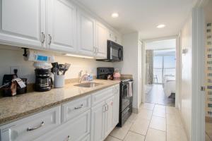 a kitchen with white cabinets and a counter top at Beachfront Bliss! Ocean Views, Lazy River, Pools, Hot Tubs, Near the Boardwalk in Myrtle Beach