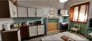een keuken met witte kasten en een tafel. bij Casa Rosata in Magliano Sabina +15 foto's