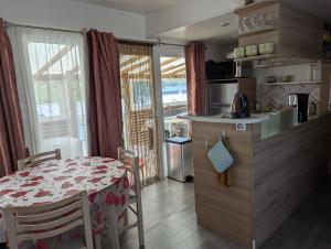 eine Küche mit einem Tisch und eine Küche mit einem Esszimmer in der Unterkunft Mobil home Apollon Riviera in Saint-Papoul + 20 Fotos
