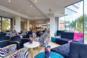 a lobby with couches and zebra chairs and tables at Cala Millor Garden Hotel - Adults Only in Cala Millor
