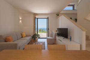 a living room with a couch and a tv at Donna Paolina Rooms & Apartments in Villammare