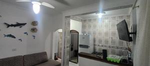 ein Wohnzimmer mit einer Theke und einem TV an der Wand in der Unterkunft Casa de Praia Bertioga-Costa do Sol Guaratuba in Bertioga