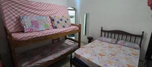 ein Schlafzimmer mit einem Etagenbett und einem kleinen Bett mit Kinderbett in der Unterkunft Casa de Praia Bertioga-Costa do Sol Guaratuba in Bertioga