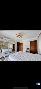 una camera da letto con un letto grande e un ventilatore a soffitto di Villa Tego a Çeşme