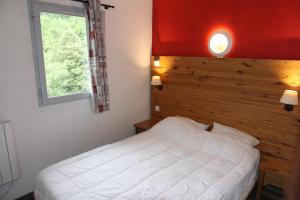 a bedroom with a white bed and a window at Appartement Duplex 4 à 6 personnes in Arreau