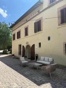 a patio with couches and chairs in front of a building at Borgo delle Mole I Bed & Breakfast in Spoleto