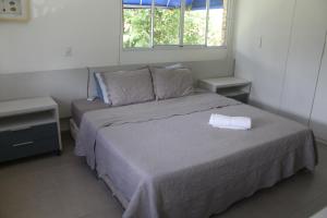 a bedroom with a bed with a white pillow on it at Casa Luxuosa - Porto de Galinhas in Porto De Galinhas +23 photos