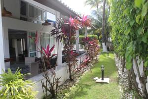 a house with a yard with plants in front of it at Casa Luxuosa - Porto de Galinhas in Porto De Galinhas