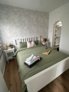 a bedroom with a large green bed with two towels at Room Mayi GC in Las Palmas de Gran Canaria