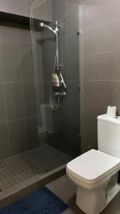 ein Bad mit Dusche, WC und Telefon in der Unterkunft Apartamento bellamente decorado en la zona 10 in La Aurora