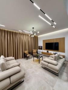 a living room with couches and a flat screen tv at Rei Green Coast Villa in Himare