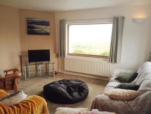 a living room with a large window and a couch at Killadoon Farm House in Killadoon