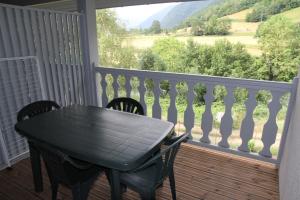a black table and chairs on a balcony with a view at Appartement Duplex 4 à 6 personnes in Arreau +4 photos