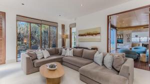 a living room with a couch and a table at Santi House - Beachfront home with ocean views in Kingscliff