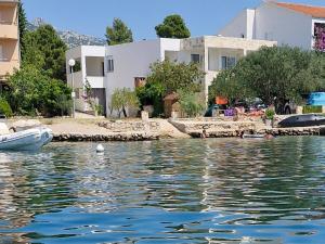 a boat in the water in front of some buildings at Apartman Lucija in Seline