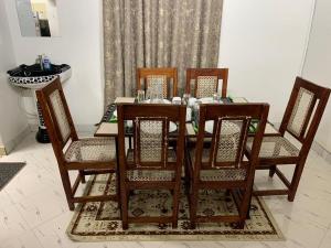 a wooden dining room table with four chairs at Fatnaish Tamarind Apartment in Lamu