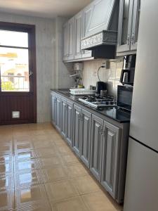 a kitchen with white cabinets and a stove top oven at La casa de la Brisa in Piles