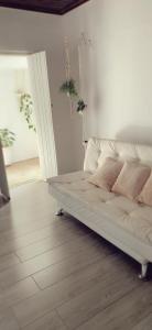 un divano bianco appoggiato su un pavimento di legno in una stanza di Casa das Plantas a Piraju