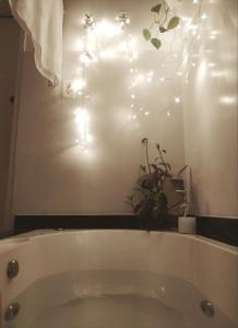 un bagno con vasca e luci alle pareti di Casa das Plantas a Piraju
