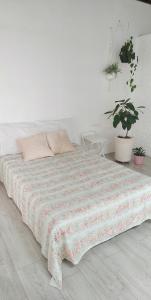 un letto in una camera bianca con piante in vaso di Casa das Plantas a Piraju