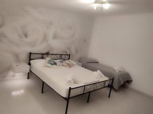 a bedroom with a bed and a white wall at Family & Friends - Room 2 - Second Floor - shared bathroom in Galtellì +9 photos