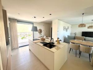 uma cozinha e sala de estar com um lavatório e uma mesa em Villa Fidel Murcia em Múrcia