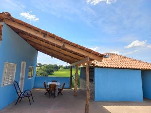 a wooden pergola on a patio with a table and chairs at pousada ceul azul #canastra in São João Batista do Glória