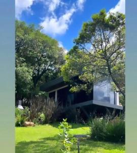 a house in the middle of a garden at Cabana QUARTZO- Vista para PONTO TURISTIC0 Pedra Morro do Campestre- ACESSO até a cabana asfaltado in Urubici