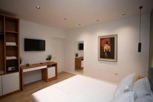 a living room with a bed and a television at Villa Klaus Center Hotel in Tirana