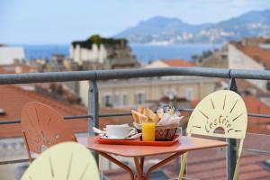 a table with a plate of food and drinks on a balcony at L'Esterel in Cannes