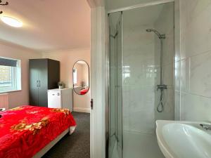 a bathroom with a red bed and a shower at New York Ensuite Double Room in London