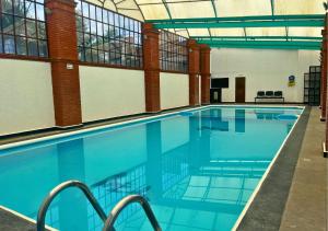a large swimming pool with blue water in a building at Hotel Real Campestre Tepetoci in Tepexi del Río