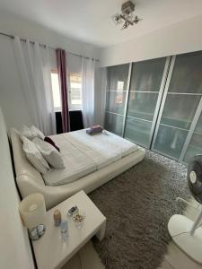 a bedroom with a large bed and a table at Quarto privado num apartamento partilhado in Bobadela