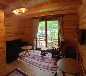 a living room with a couch and a table at ELASYA BUNGALOV in Rize