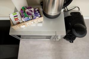 a counter top with a coffee maker and a table with snacks at Fortuna Park Apartman in Sfântu-Gheorghe