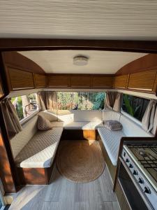 an interior of a rv with two beds and a stove at Trailer Vintage no Sítio Wanderlust in Rolante