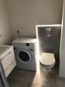Un baño con lavadora y un inodoro. en Apartamenty Platinum 3, en Gdansk 1 foto más