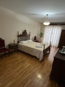Un dormitorio con una cama grande y suelo de madera. en Refúgio do Sabor, en Mogadouro