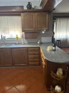 Una cocina con gabinetes de madera y encimera. en Refúgio do Sabor, en Mogadouro