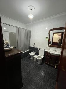 Un baño con inodoro, lavabo y espejo. en Refúgio do Sabor, en Mogadouro