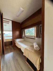 a small room with two beds and a window at Trailer Vintage no Sítio Wanderlust in Rolante