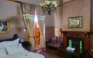 a bedroom with a bed and a chair and a window at The Journey GuestHouse in Ladybrand