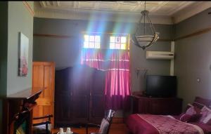 a room with a bed and a window with a rainbow at The Journey GuestHouse in Ladybrand +8 photos