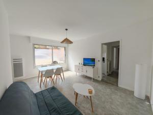 a living room with a bed and a table and chairs at Malo-les-Bains Appartement 1 chambre in Dunkerque