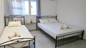 deux lits jumeaux dans une chambre avec fenêtre dans l'établissement MakaLand Studio Corfu, à Evropoúloi