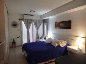 Hermoso departamento céntrico! في سان ميغيل دي توكومان: غرفة نوم بسرير ازرق ونافذة