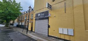 a building with a garage door on the side of a street at New York Ensuite Double Room in London