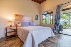 a bedroom with a large bed and a window at Getaway & Ocean Breeze - Secluded & Natural Charming - 2 bedrooms in Barú +21 photos