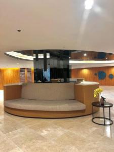 a large couch in a lobby with a table at Hotel De Rama Unit 5115 near MOA and NAIA in Manila +7 photos
