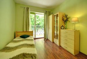 ヴィスワにあるApartamenty Sun Seasons 24 - Bukowaのベッドルーム1室(ベッド1台、ドレッサー、窓付)